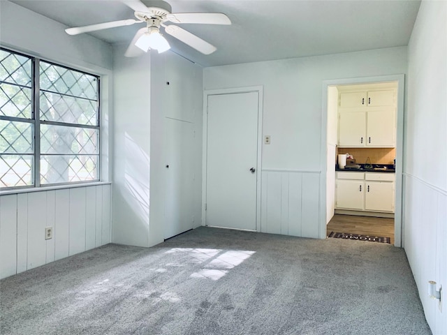 unfurnished bedroom featuring ceiling fan, a closet, and carpet floors