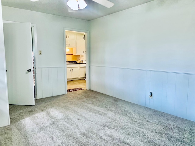 empty room featuring light colored carpet and ceiling fan