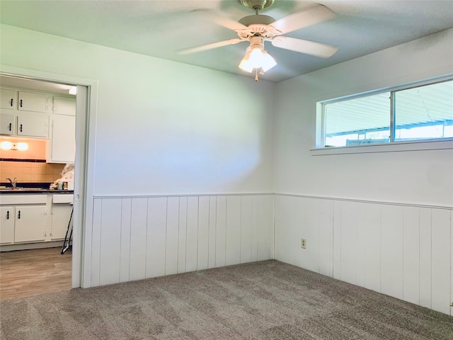 carpeted spare room with ceiling fan and sink