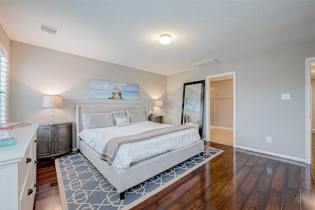 bedroom featuring a textured ceiling, a spacious closet, dark wood-type flooring, and a closet