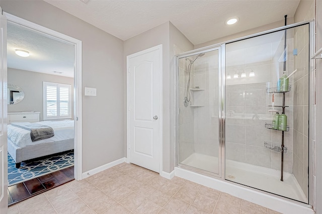 bathroom with a shower with shower door and a textured ceiling