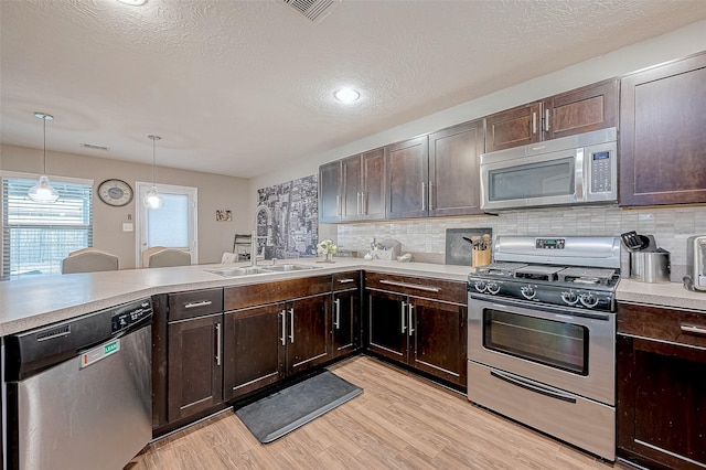 kitchen featuring backsplash, pendant lighting, sink, and stainless steel appliances