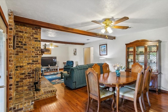 dining space featuring beamed ceiling, hardwood / wood-style floors, a textured ceiling, and ceiling fan