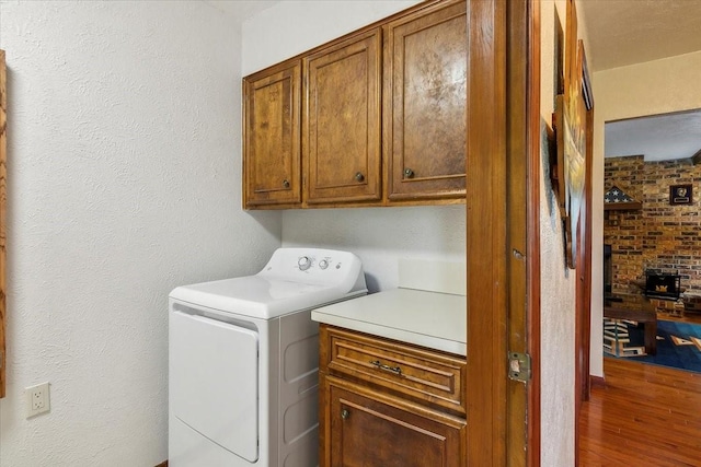 laundry room with hardwood / wood-style flooring, cabinets, and washer / clothes dryer