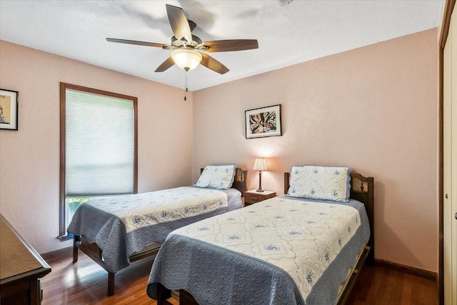 bedroom featuring ceiling fan, dark wood-type flooring, and a closet