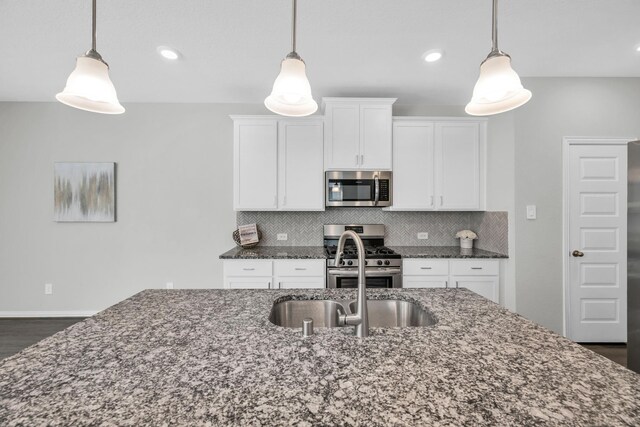 kitchen featuring stainless steel appliances, hanging light fixtures, and tasteful backsplash