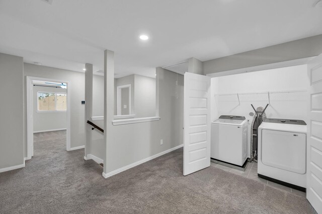 washroom with washing machine and dryer and light carpet