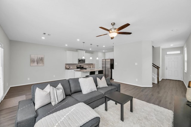 living room with ceiling fan and light hardwood / wood-style flooring