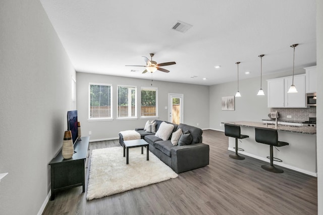 living room featuring ceiling fan and wood-type flooring