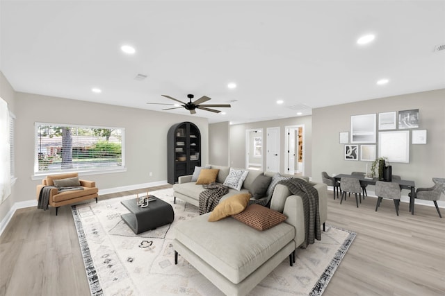 living room with ceiling fan and light hardwood / wood-style flooring