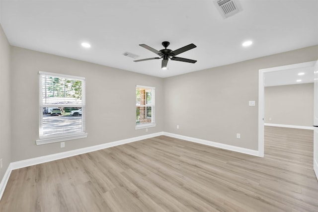 spare room with plenty of natural light, ceiling fan, and light hardwood / wood-style flooring