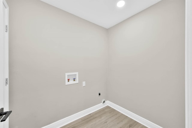 laundry area with hookup for an electric dryer, hookup for a washing machine, and light hardwood / wood-style floors