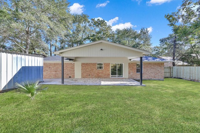 rear view of property with a yard and a patio