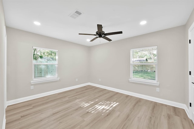 spare room with plenty of natural light, light hardwood / wood-style floors, and ceiling fan