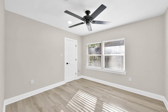 empty room with ceiling fan and light hardwood / wood-style flooring