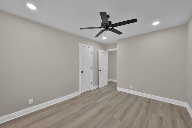 empty room with ceiling fan and light hardwood / wood-style floors