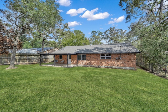 rear view of property with a lawn and a patio area