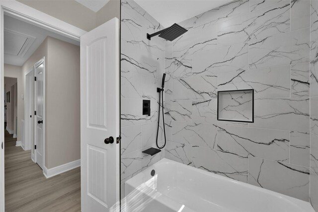 bathroom with tiled shower / bath combo and hardwood / wood-style flooring