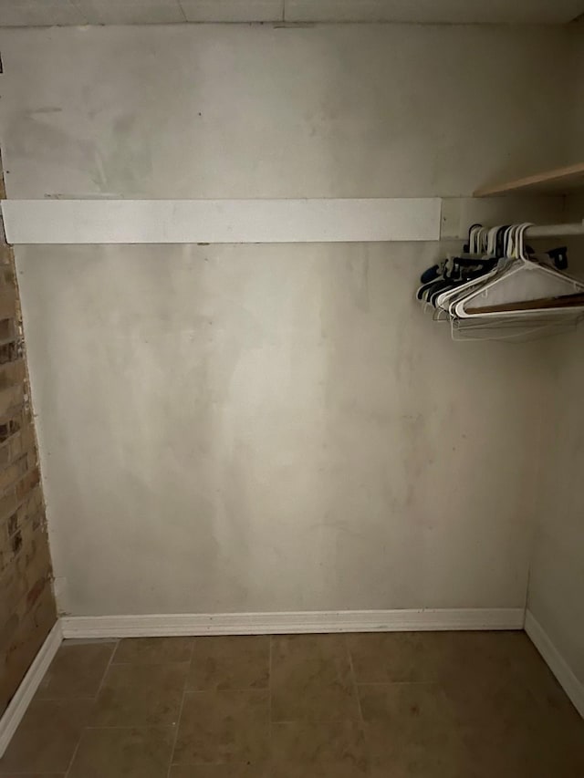 walk in closet featuring dark tile patterned flooring