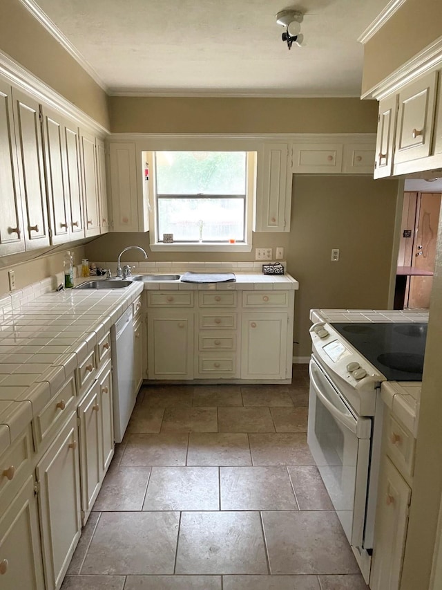 kitchen with tile countertops, white appliances, sink, ornamental molding, and light tile patterned floors