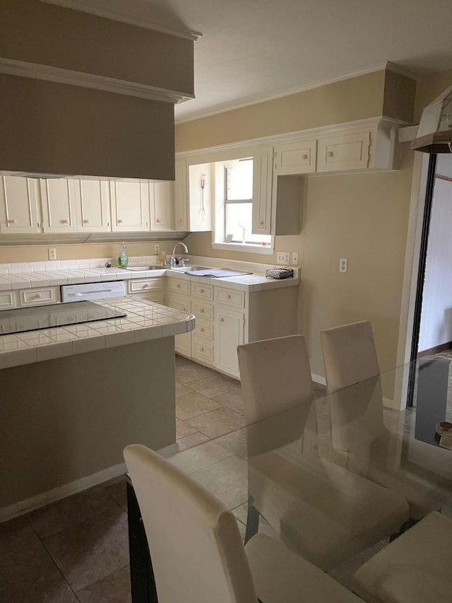 kitchen featuring tile countertops, dishwasher, white cabinets, and crown molding