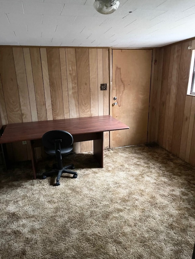 carpeted office featuring wooden walls