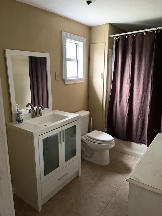 full bathroom featuring tile patterned floors, vanity, toilet, and shower / tub combo with curtain