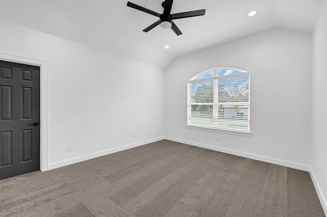 carpeted spare room featuring ceiling fan and vaulted ceiling