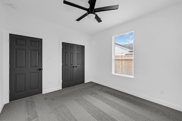 unfurnished bedroom featuring ceiling fan and dark carpet