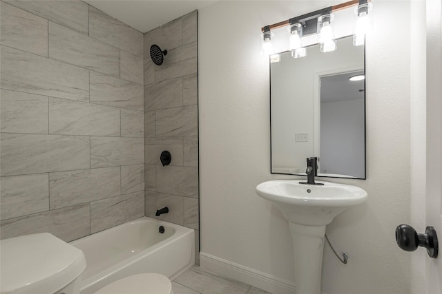 full bathroom featuring tile patterned floors, tiled shower / bath combo, toilet, and sink