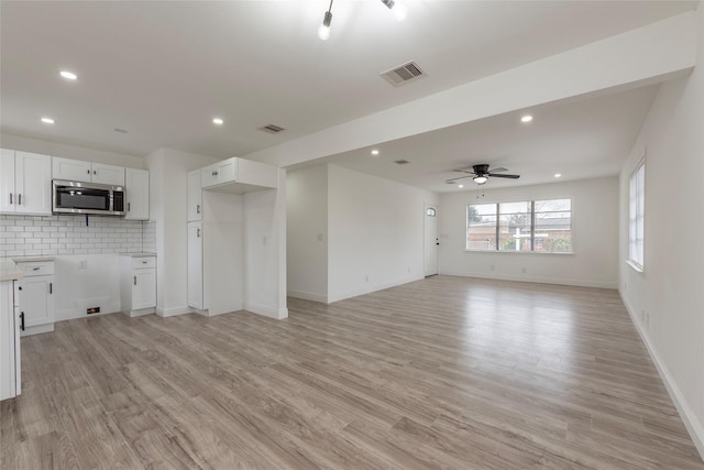 interior space with light wood finished floors, visible vents, and recessed lighting