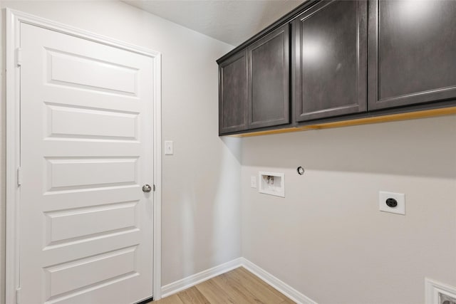 laundry room with electric dryer hookup, hookup for a washing machine, cabinets, light hardwood / wood-style flooring, and hookup for a gas dryer