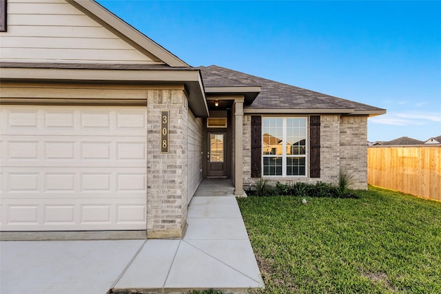 doorway to property featuring a garage and a lawn