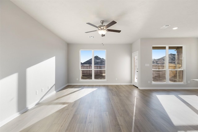 empty room with ceiling fan, light hardwood / wood-style flooring, and a wealth of natural light