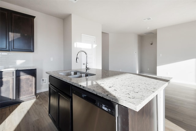 kitchen with sink, light hardwood / wood-style flooring, stainless steel dishwasher, an island with sink, and light stone countertops