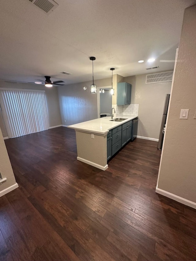 kitchen featuring dishwasher, sink, tasteful backsplash, kitchen peninsula, and decorative light fixtures