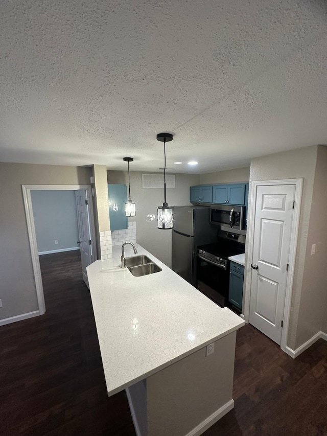 kitchen with pendant lighting, sink, blue cabinetry, appliances with stainless steel finishes, and kitchen peninsula