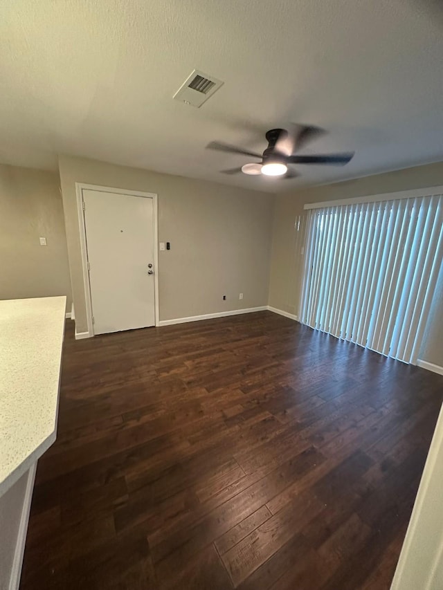 empty room with dark hardwood / wood-style floors and ceiling fan