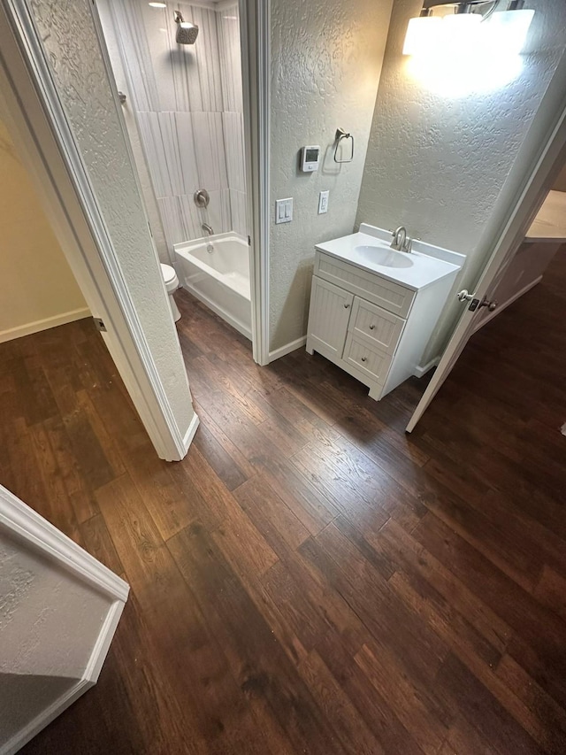 full bathroom featuring shower / tub combination, hardwood / wood-style floors, vanity, and toilet