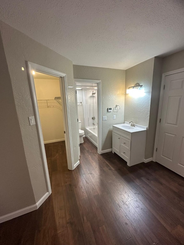 bathroom with toilet, vanity, a textured ceiling, and hardwood / wood-style flooring