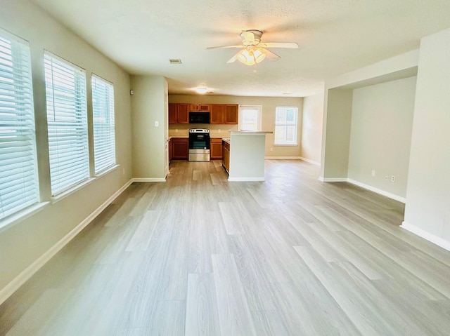 unfurnished living room with ceiling fan and light hardwood / wood-style floors