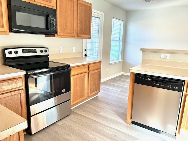 kitchen featuring a healthy amount of sunlight, light hardwood / wood-style flooring, and appliances with stainless steel finishes