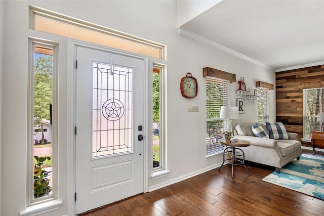 entryway with wooden walls, ornamental molding, and dark wood-type flooring