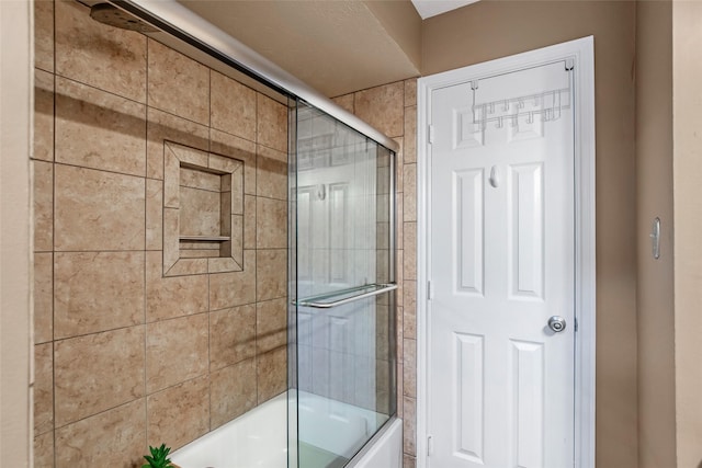 bathroom featuring combined bath / shower with glass door