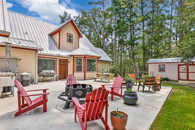 rear view of property featuring an outdoor fire pit, a patio, and an outdoor structure