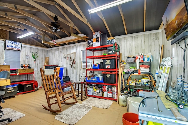 basement with ceiling fan, a workshop area, and wooden walls