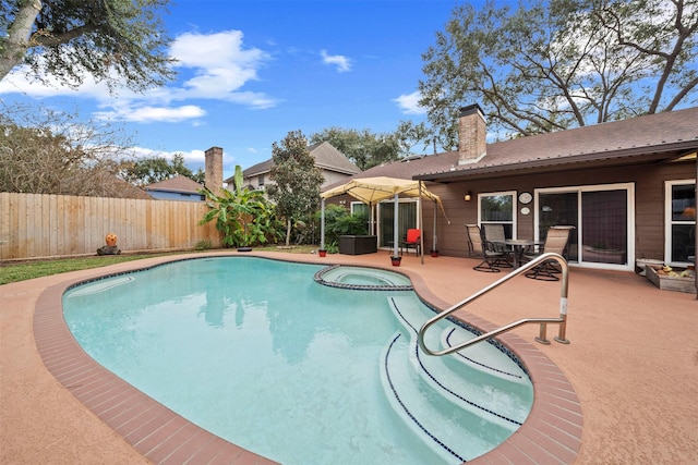 view of pool featuring a patio area and an in ground hot tub