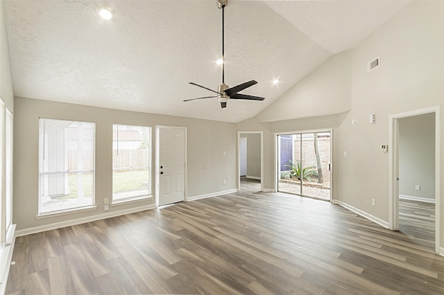 unfurnished living room with hardwood / wood-style flooring, ceiling fan, high vaulted ceiling, and a textured ceiling