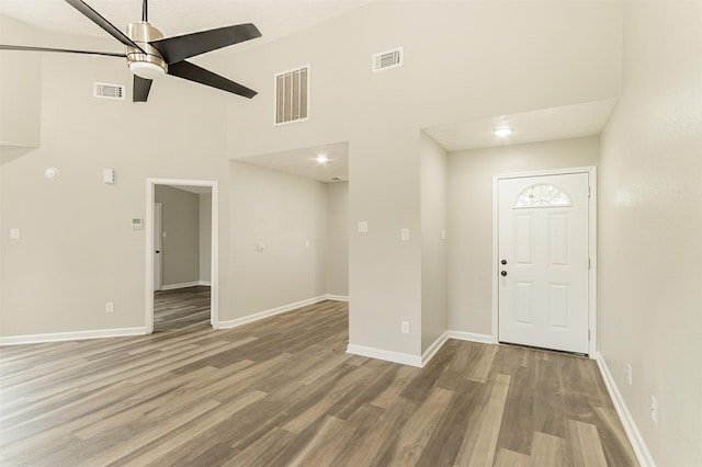 entryway featuring a high ceiling, hardwood / wood-style floors, and ceiling fan