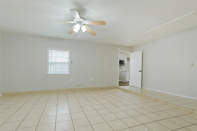 tiled spare room featuring ceiling fan